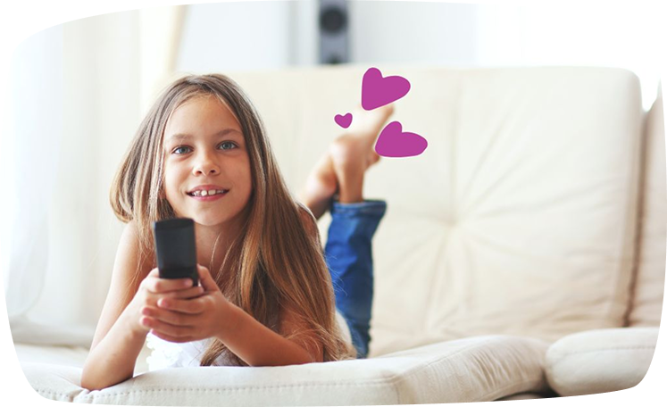 Seorang budak perempuan di atas sofa memegang alat kawalan jauh