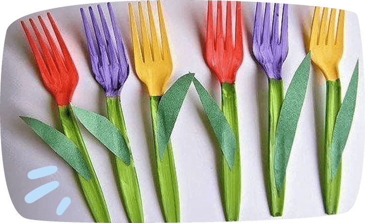Enam buah garpu plastik berwarna-warni yang dihias menyerupai bunga tulip, lengkap dengan batang dan daun daripada kertas hijau, disusun di atas permukaan putih.