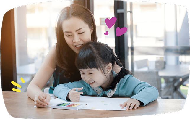Babysitter and young girl drawing together at a table